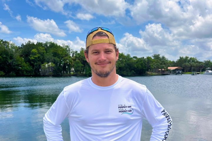 a man standing next to a body of water