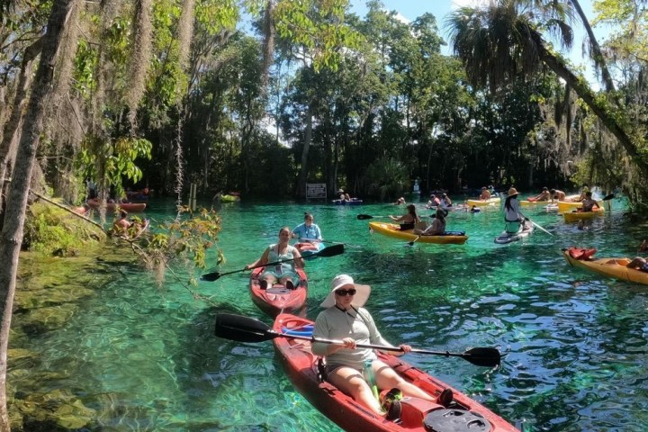 a group of people riding on the back of a boat in the water