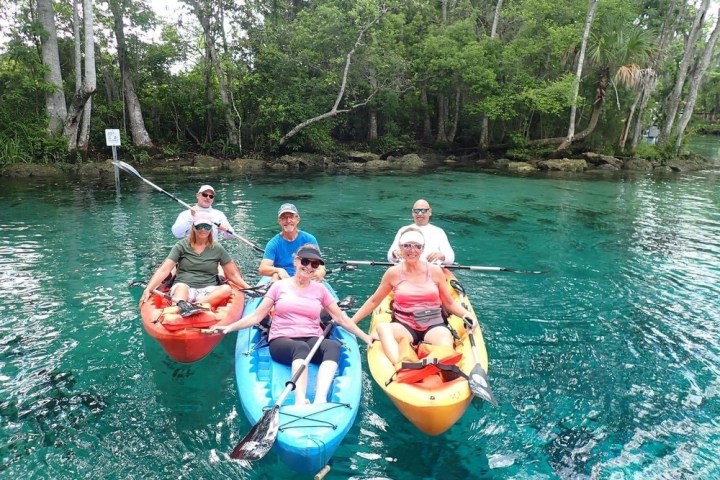 a group of people riding on the back of a boat in the water