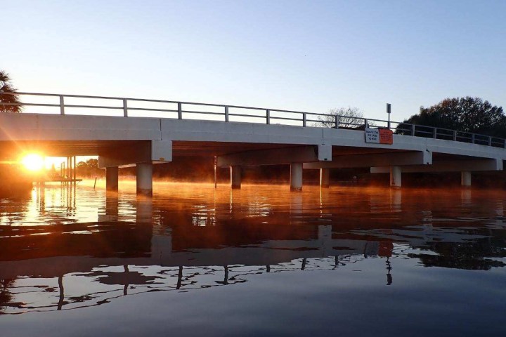 a train crossing a bridge over a body of water