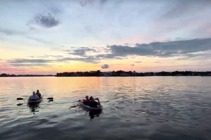 a group of people in a small boat in a body of water